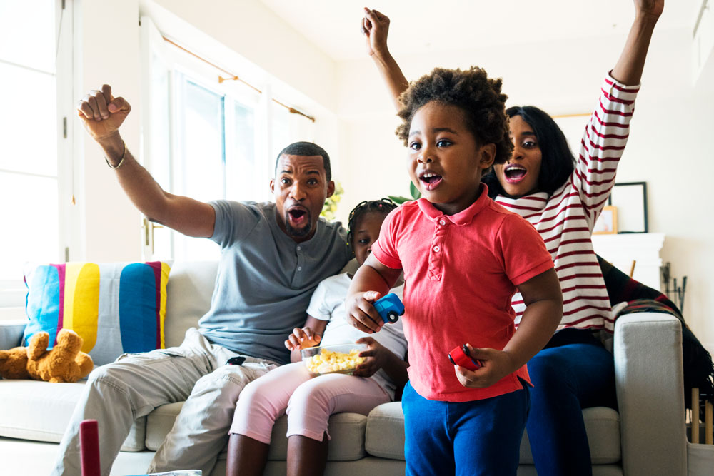 Family watching tv and cheering